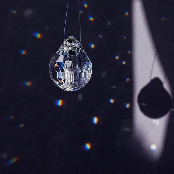 Single faceted glass teardrop pendant and its shadow projection