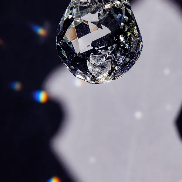 High-contrast close-up of a faceted glass teardrop pendant