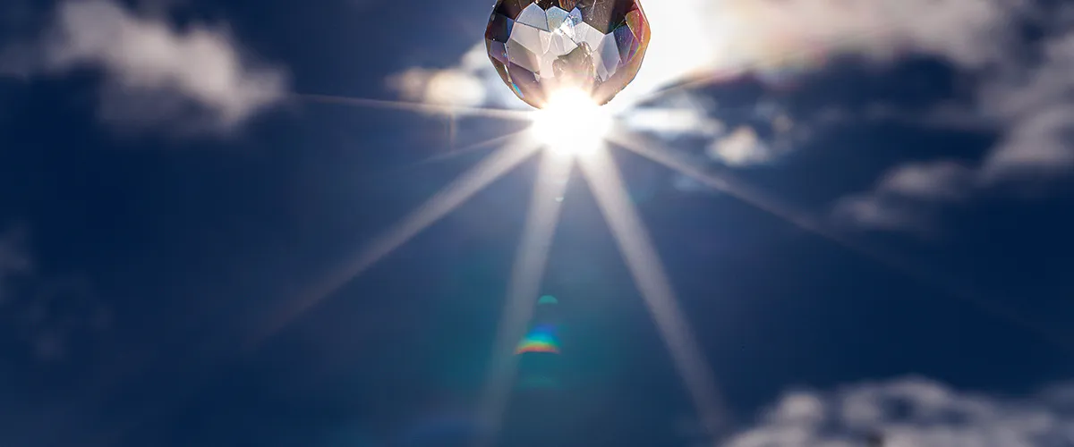 Wide panoramic shot of hanging memorial crystal backlit by sun